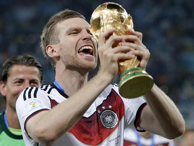 Germany's Per Mertesacker celebrates with the trophy after the World Cup final football match between Germany and Argentina at the Maracana Stadium in Rio de Janeiro, Brazil on July 13, 2014. (AP Photo/Matthias Schrader)
