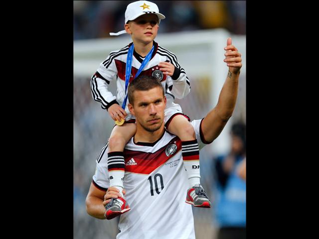 Germany's Lukas Podolski carries his son Louis Gabriel after the World Cup final between Germany and Argentina. Germany beat Argentina 1-0 to win its fourth World Cup title. (AP Photo/Frank Augstein)