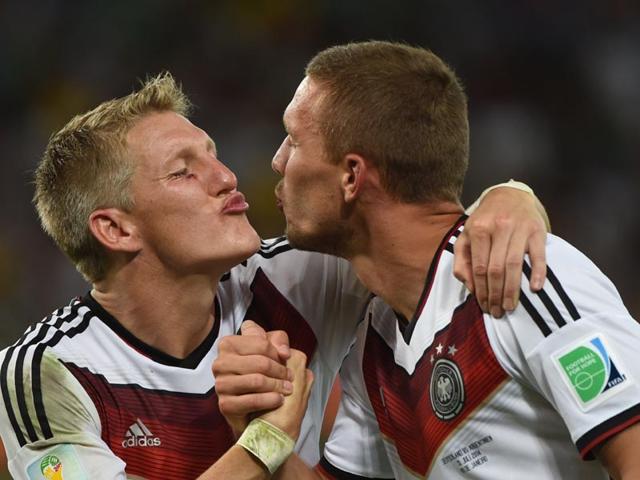Germany's midfielder Bastian Schweinsteiger (L) and Germany's forward Lukas Podolski celebrate after winning the 2014 FIFA World Cup final football match between Germany and Argentina 1-0 following extra-time on July 13, 2014. (AFP PHOTO/Patrik Stollarz)