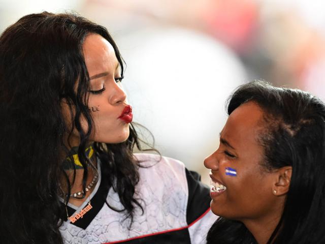 Barbadian singer Rihanna jokes with a friend during the FIFA World Cup final football match between Germany and Argentina at the Maracana Stadium in Rio de Janeiro on July 13, 2014. (AFP/Gabriel Bouys)