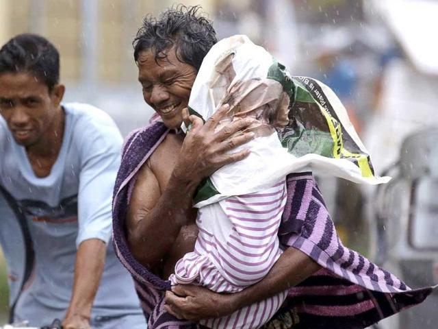 Residents of the slum community of Baseco evacuate to safer grounds at the onslaught of typhoon Rammasun in Manila in Manila, Philippines. Typhoon Rammasun left at least seven people dead and knocked out power in many areas Wednesday but the Philippine capital and densely populated northern provinces were spared a direct battering when its fierce winds shifted slightly. (AP Photo)