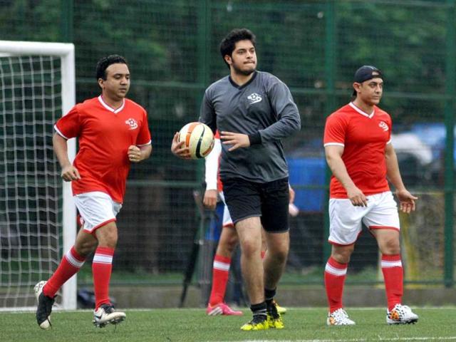 Actor Aamir Khan (R), his son Junaid Khan (C) and music director Ram Sampat play during a charity football match organized by Ira Khan, daughter of film actor Aamir Khan in Mumbai on July 20, 2014. (AFP)