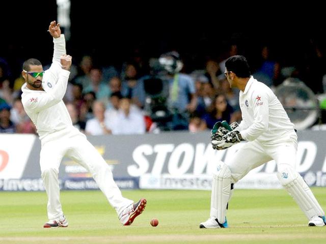 Shikhar Dhawan regains his balance after stopping the ball at slip beside his captain Mahendra Singh Dhoni at Lord's cricket ground in London (AP Photo)