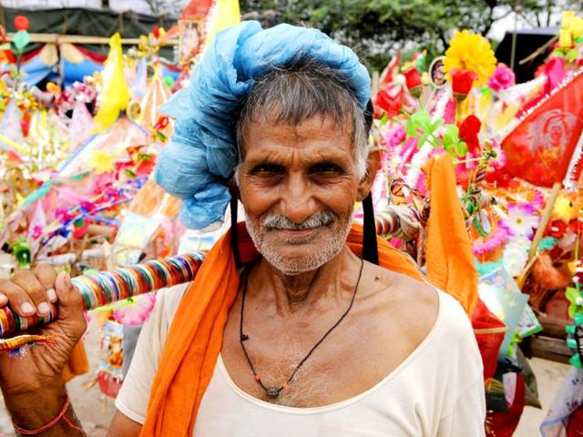 Devotees known as Kanwarias carry the holy water which they collect from the holy River Ganges, on their way to different Hindu temples in their hometowns to offer the holy water to the idol of Lord Shiva in Noida, India. (HT Photo/Burhaan Kinu)