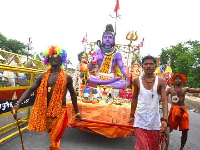 Kanwarias or devotees of Shiva pick up their Ganga water carriers at NH 58 in Ghaziabad. (HT Photo/Sakib Ali)