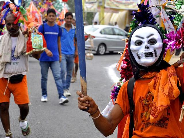 Kanwarias or devotees of Shiva pick up their Ganga water carriers at NH 58 in Ghaziabad. (HT Photo/Sakib Ali)