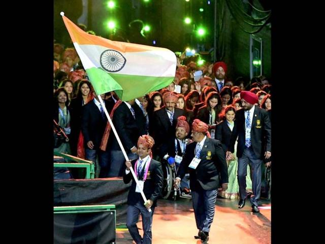 Ace shooter Vijay Kumar holds the Tricolour as he leads the Indian contingent. (PTI Photo)