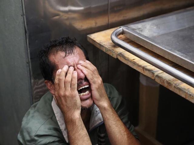 Gaza, Beit Lahiya: A Palestinian man cries after identifying the body of his loved one, killed in an Israeli strike, inside the morgue of Kamal Adwan hospital in Beit Lahiya, northern Gaza Strip on July 24, 2014. (AP/Lefteris Pitarakis)