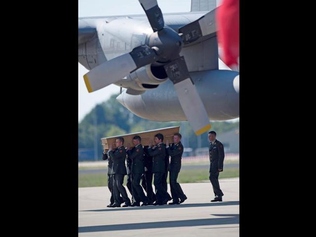 Eindhoven military air base: Soldiers unload coffins during a ceremony to mark the return of the first bodies of passengers and crew killed in the downing of Malaysia Airlines Flight 17, from Ukraine on July 23, 2014. (AP/Martin Meissner)