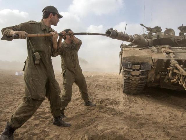 Israel, Israel-Gaza Border: Israeli soldiers work on their Merkava tank at an army deployment area near Israel's border with the Gaza Strip, on July 24, 2014. (AFP/Jack Guez)