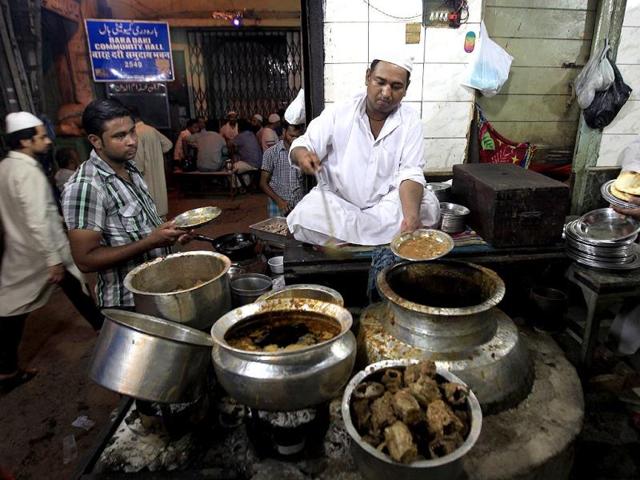 A vendor dishes out Ramzan delicacies near Jama Masjid between Iftar and Sehri at old Delhi. (HT Photo/Ajay Aggrwal)
