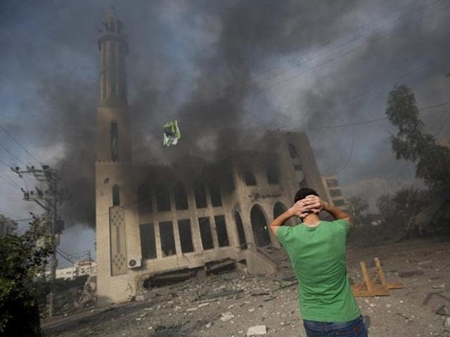 A Palestinian man reacts in front of a destroyed mosque after it was hit by an Israeli air strike on July 29, 2014. Bloodshed in and around Gaza surged with strikes killing at least 13 Palestinians, a day after five Israeli soldiers died, shattering hopes for an end to three weeks of violence. (AFP/Mahmud Hams)