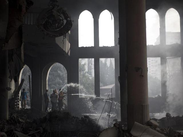 Palestinian firefighters extinguish fire at a mosque after it was hit by an Israeli air strike on July 29, 2014, in Gaza City. (AFP/Mahmud Hams)