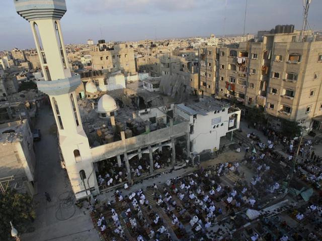 Palestinians pray early morning prayer during the first day of Eid al-Fitr at the destroyed Al Farouk mosque on July 28, 2014. As Muslims began celebrating on Monday, there was mostly fear and mourning instead of holiday cheer in the Gaza Strip. (AP/Eyad Baba)