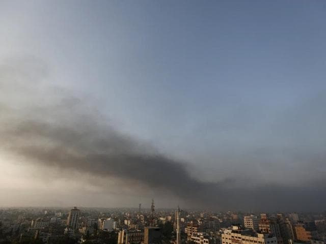 Smoke from Israeli strikes rises over Gaza City early as the sun rises on July 29, 2014. The overnight strikes came after a day of heavy Hamas-Israeli fighting in which nine children were killed by a strike on a Gaza park where they were playing. (AFP/Mohammed Abed)