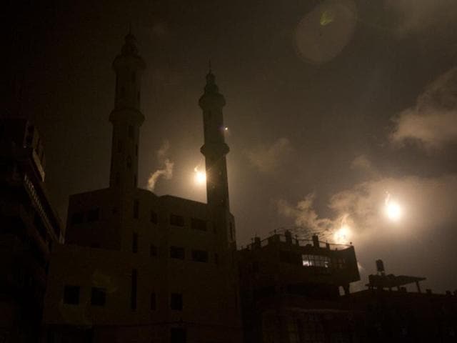 Israeli forces' flares light up the night sky of Gaza City on 29 July, 2014. Bloodshed in and around Gaza surged with a strike killing eight Palestinian children and a mortar shell leaving four dead in Israel, shattering hopes for an end to three weeks of devastating violence. (AFP/Mahmud Hams)