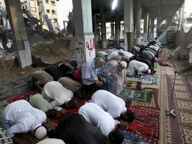 Palestinians pray early morning prayer during the first day of Eid al-Fitr, which marks the end of the Muslim fasting month of Ramadan, inside the destroyed Al Farouk mosque which was destroyed by an overnight Israeli strike on Tuesday, in Rafah, in the southern Gaza Strip. (AP Photo/Eyad Baba)