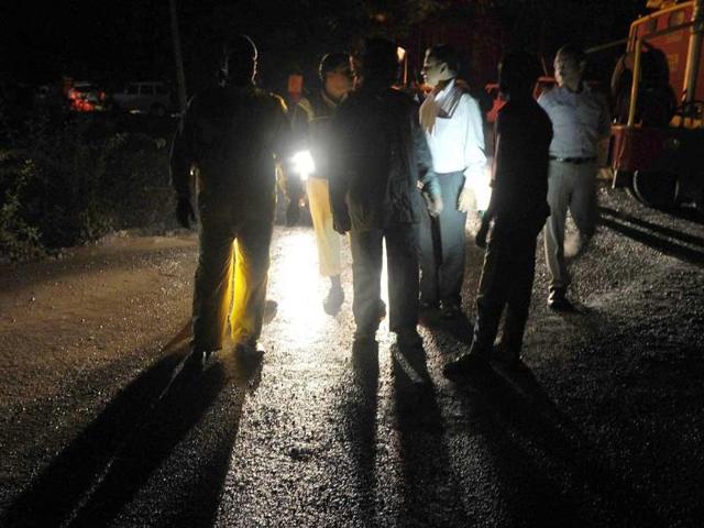 Disaster relief and rescue officials are seen at a barricade set up by police some 35 kms before the site of a landslide in Malin village in Pune district. (AFP Photo)
