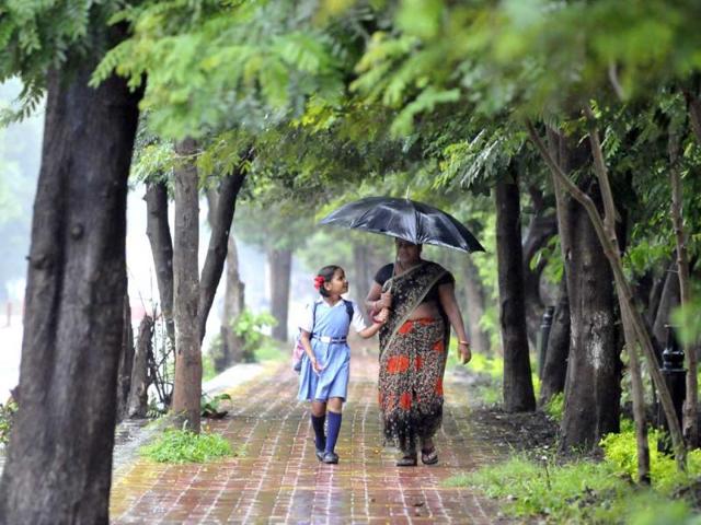 A schoolgirl and her mother enjoy light showers in Bhopal on Tuesday. (HT photo)