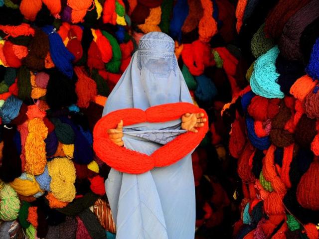 An Afghan woman buys silk yarn for weaving from a shop in Herat. (AFP photo/Aref Karimi)