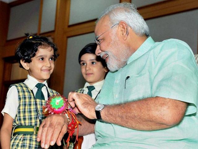 Children tie rakhi to Prime Minister Narendra Modi in New Delhi. (PTI Photo)