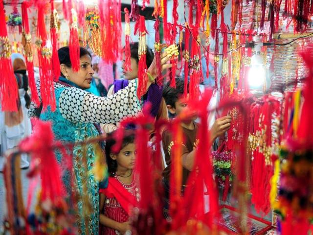 Pakistani women look at rakhis at a roadside shop ahead of Raksha Bandhan in Karachi. (AFP Photo)