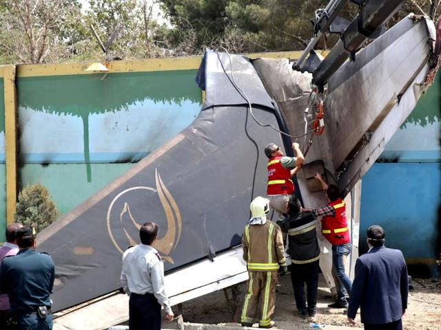 Iranian rescue personnel work at the site of a passenger plane crash near the capital Tehran, Iran. The Sepahan Air Iran-140 regional plane crashed killing tens of people onboard, shortly after takeoff from Tehran's Mehrabad airport on its way to Tabas, a town in eastern Iran, state media reported. (AP photo)