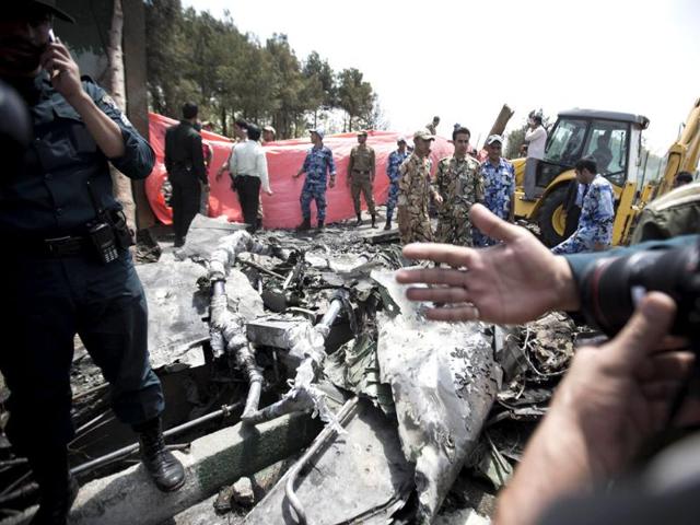 Iranian security forces prevent photographers from taking pictures of the remains of a plane as they secure the scene of a crash near Tehran's Mehrabad airport. (AFP photo)
