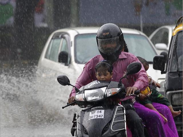 Delhiites having fun in rain at Mandi House circle, in New Delhi. (Arvind Yadav/HT Photo)