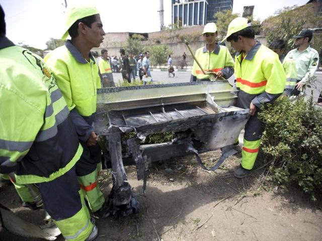 Municipality workers remove the remains of a Iranian plane to clean up the scene of a crash near Tehran's Mehrabad airport. (AFP photo)