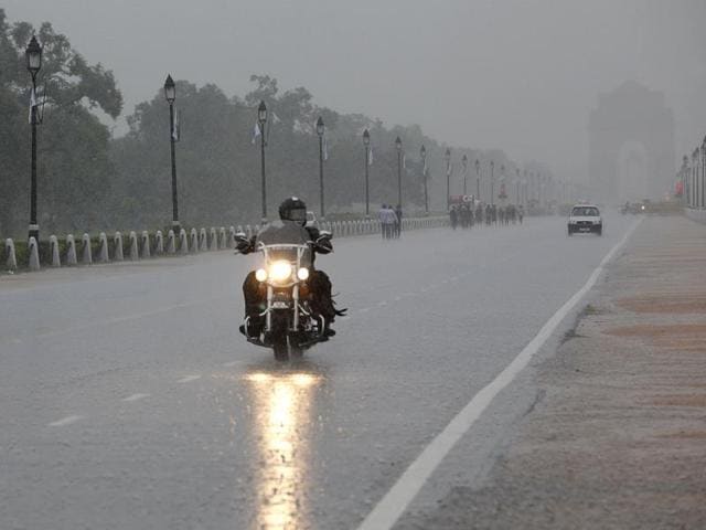 A man enjoys the rain out on a bike ride. (Arvind Yadav/HT Photo)