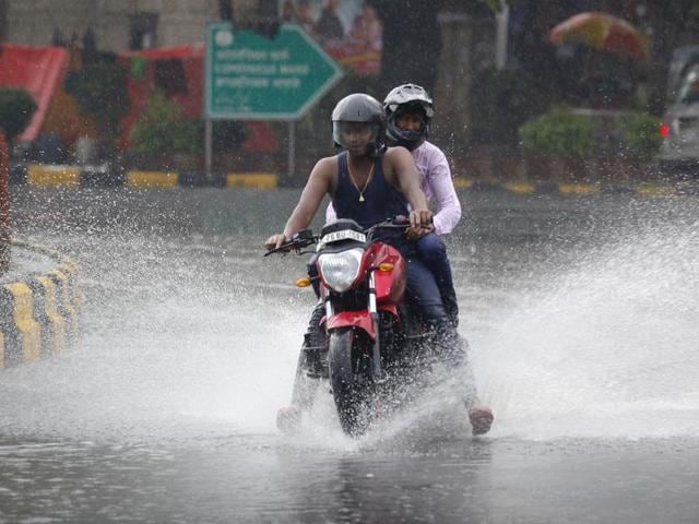 Delhiites having fun in rain at Mandi House circle, in New Delhi. (Arvind Yadav/HT Photo)