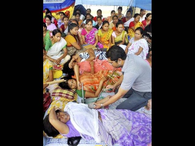 A doctor checking the health condition of activists of All Assam Jyoatikendra Siksha Santha (AAJSS) during their indefinite hunger strike for regularisation of jobs at Dispur in Guwahati. (PTI Photo)