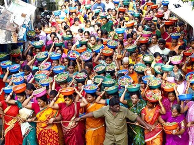 Devotees carry flowers on their heads at a temple on the occasion of last Sunday of Tamil month Aadi in Chennai. (PTI Photo)