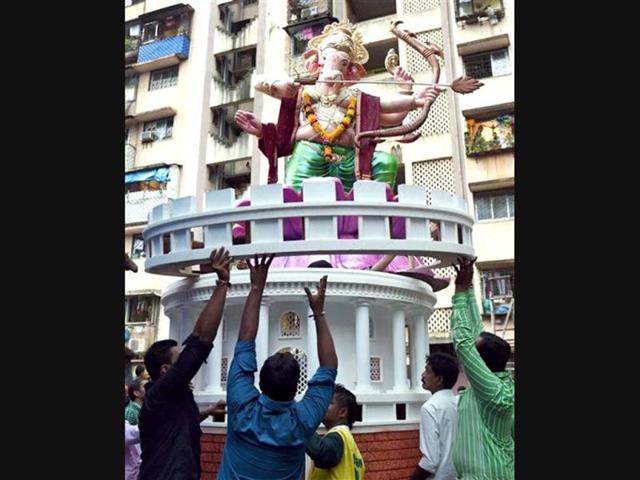 Artists give final touch to an idol of Lord Ganesh before taking it to the pandals for the upcoming Ganesh festival in Mumbai. (PTI Photo)