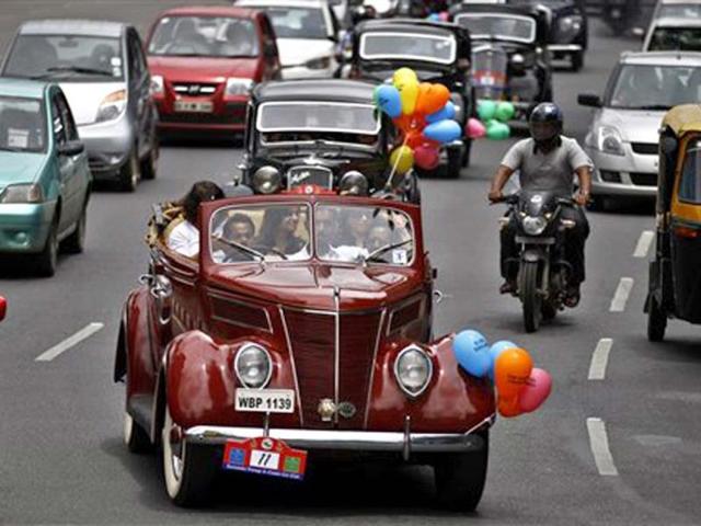 People drive vintage cars decorated with colored balloons printed with messages denouncing rape during a rally organized to create awareness about sexual violence against women and children, in Bangalore. (AP Photo)