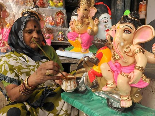 A woman gives finishing touches to idols of Lord Ganesh ahead of Ganesh Utsav which begins on August 29. (Arun Mondhe/HT photo)