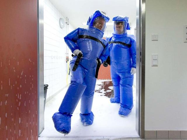 Doctor for tropical medicine Florian Steiner (R) and ward physician Thomas Klotzkowski step out of a disinfection chamber after cleaning their protective suits, at the quarantine station for patients with infectious diseases at the Charite hospital in Berlin. (REUTERS Photo)