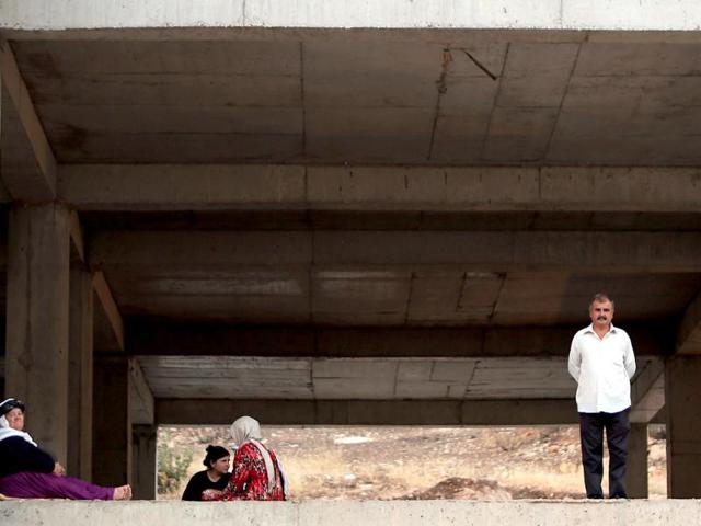 Iraqis from the Yazidi community stand in a building under construction used as shelter after their fled their hometown which was attacked by Sunni militants from the Islamic state in Dohuk. (AFP photo)