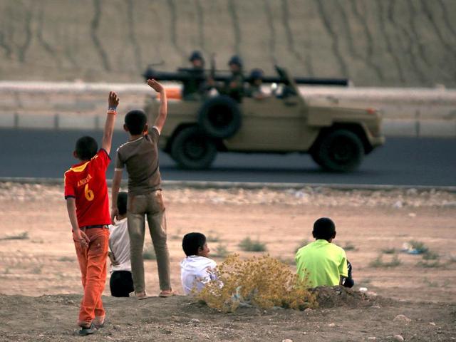 Iraqi children from the Yazidi community wave to Kurdish Peshmerga forces near Dohuk, Iraq, after they fled with their families their hometown which was attacked by Sunni militants from the Islamic state. (AFP photo)