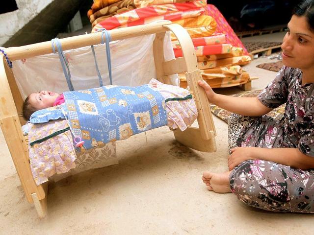 An Iraqi woman from the Yazidi community isits near her baby in a building under construction used as shelter after their fled their hometown of Sinjar which was attacked by Sunni militants from the Islamic state in Dohuk. (AFP photo)