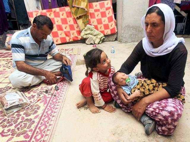 Iraqis from the Yazidi community sit in a building under construction used as shelter after their fled their hometown which was attacked by Sunni militants from the Islamic state (IS) in Dohuk. (AFP photo)