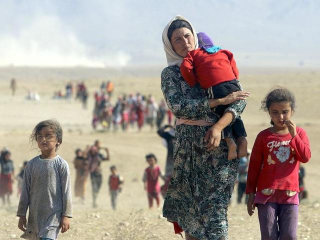 Displaced people from the minority Yazidi sect walk towards the Syrian border, on the outskirts of Sinjar mountain, near the Syrian border town of Elierbeh of Al-Hasakah governorate. (Reuters photo)