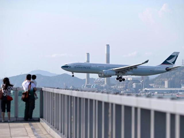 People watch as a Cathay Pacific passenger plane prepares to land at Hong Kong's international airport. (AFP photo)