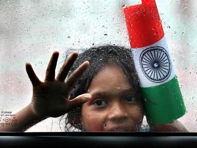 A street girl sells Indian flags on a rainy morning at Nizamuddin crossing in New Delhi. (Raj K Raj/HT Photo)
