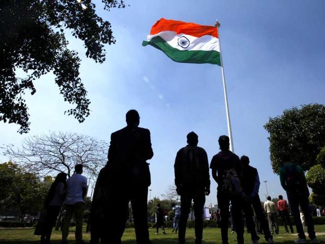 People stand for the national anthem during the flag hoisting at the highest monumental flagpole at Central Park, Rajiv Chowk in New Delhi. (Ajay Aggarwal/HT Photo)