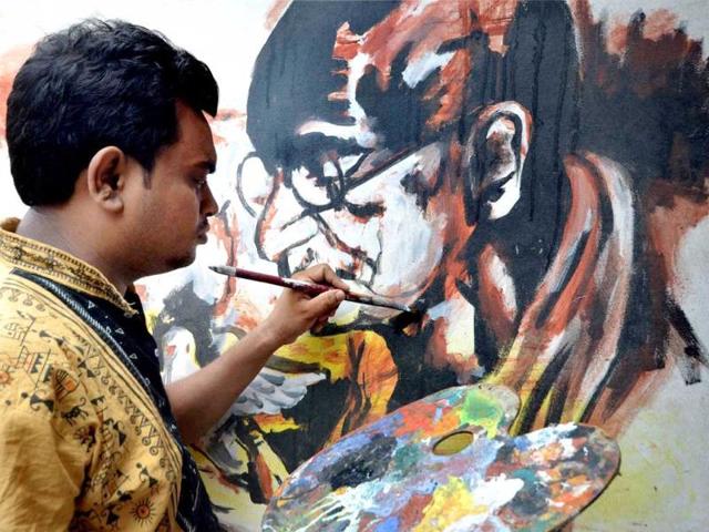 Artist Sujit Das draws a painting of great leader of freedom movement Mahatma Gandhi paying his respect and tribute on the eve of 68th Independence Day in Nagaon district of Assam (PTI Photo)