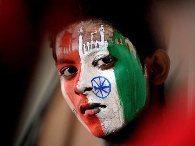 A student with social message and the colours of the Indian tricolour painted on his face in Mumbai (AFP Photo)
