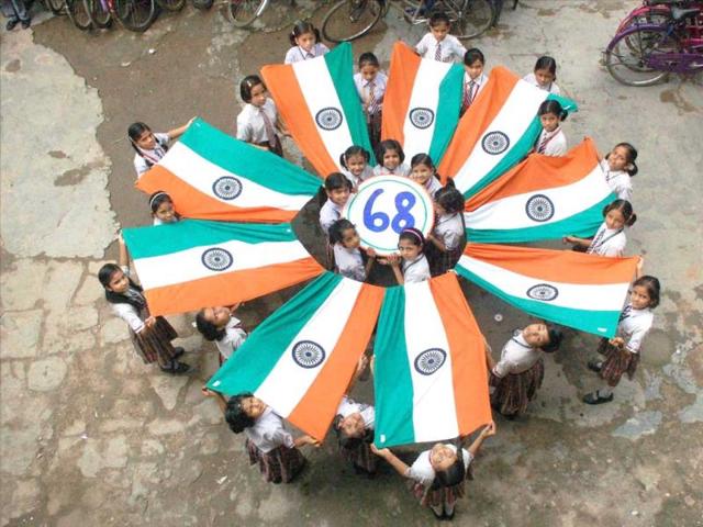 School girls celebrate with national flag on the eve of Independence day in Mirzapur on Thursday (PTI Photo)