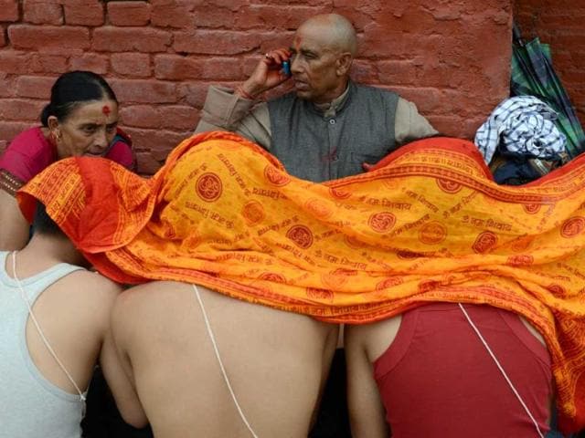 Nepalese devotees receive a Janai or sacred thread, which is a yellow cotton string worn across the chest or tied around the wrist of the right hand, from a priest during the Janai Purnima Festival at The Pashupatinath Temple in Kathmandu. (AFP photo)